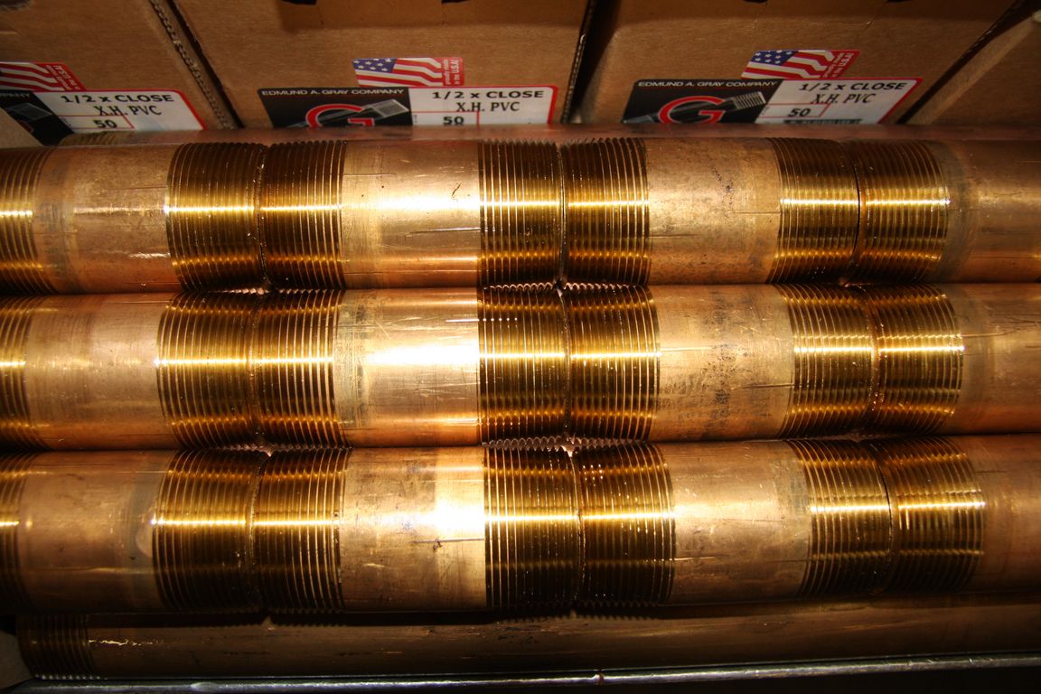 Brass pipe nipples stacked in boxes at Edmund A. Gray Company warehouse
